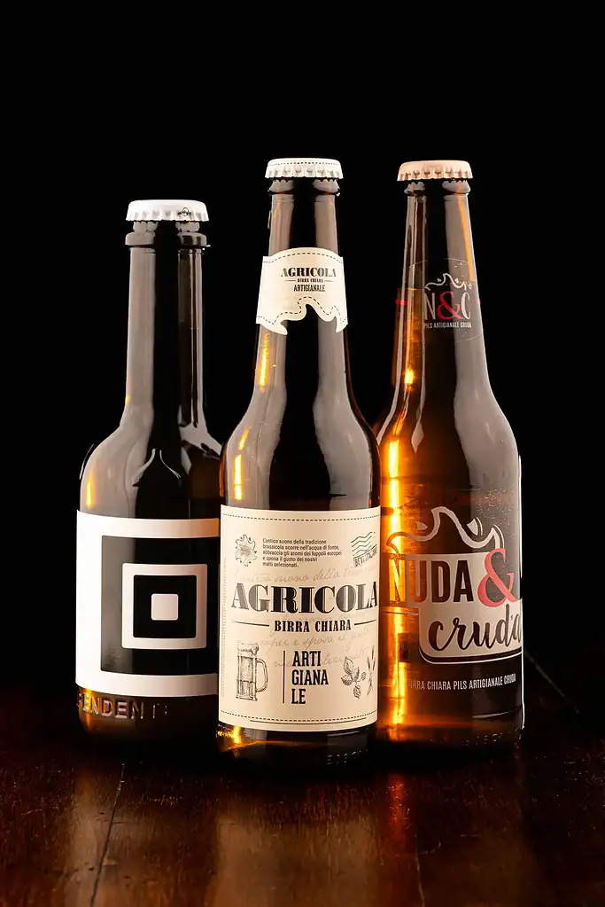 Tre birre artigianali, fotografate con toni caldi e familiari, come fossero sul bancone del tuo pub di fiducia.