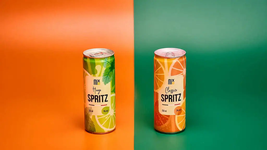 Due lattine di spritz (hai letto bene) fotografate su due fondali con colori opposti.
